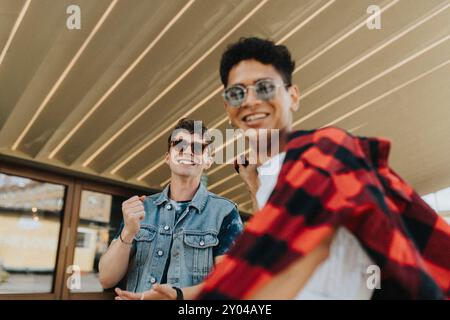 Portrait à faible angle de jeunes amis masculins à la mode dans des lunettes de soleil profitant du temps de loisirs Banque D'Images