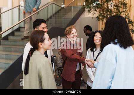 Souriant hommes et femmes entrepreneurs d'affaires se saluant les uns les autres pendant le séminaire au centre de congrès Banque D'Images