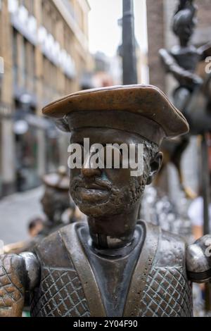Statue d'un homme portant des lunettes et un chapeau traditionnel, faisant partie de la fontaine en bronze de Puppenbrunnen dans la vieille ville historique d'Aix-la-Chapelle. Banque D'Images