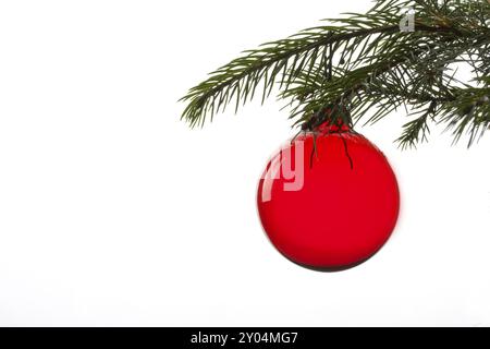 Boule rouge d'arbre de noël suspendue à la feuille d'épicéa Banque D'Images