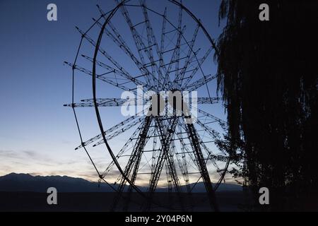 Une photographie de la silhouette d'une vieille grande roue à Toktogul, Kirghizistan, Asie Banque D'Images