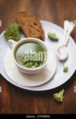 Au-dessus d'une soupe saine et savoureuse à la crème de brocoli servie dans un mug en céramique blanche sur une table en bois avec pain grillé Banque D'Images