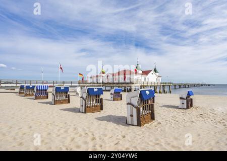 La jetée historique d'Ahlbeck sur l'île ensoleillée d'Usedom sur la mer Baltique. Chaises de plage vides au premier plan Banque D'Images