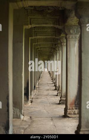 La belle série répétitive de piliers en pierre sculptée qui entoure le mur intérieur du temple d'Angkor Banque D'Images