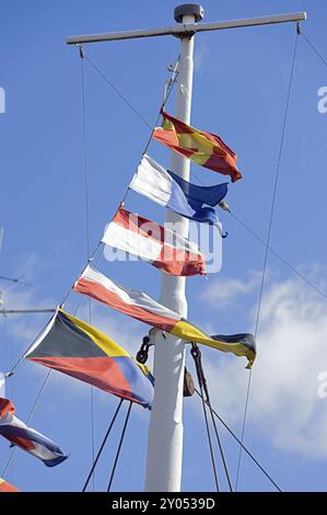 Drapeaux colorés sur un mât devant un ciel bleu. Drapeaux colorés devant le ciel bleu Banque D'Images