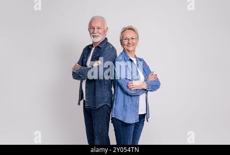 Portrait de couple senior souriant avec les bras croisés debout avec confiance sur fond blanc Banque D'Images