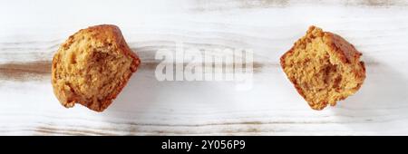 Muffin orange cassé sur un panorama de table de cuisine en bois rustique, top shot avec espace de copie Banque D'Images