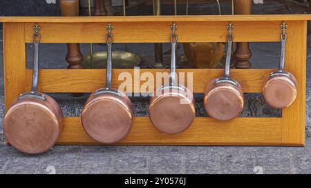 Batterie de casseroles en cuivre fixée au plateau en bois Banque D'Images