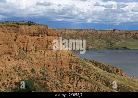 Ein felsiger Canyon, der sich an einem See mit dichtem grauen Himmel darueber erstreckt, Barrancas de Burujon, Burujon, rio Tajo, Fluss Tajo, embalse Banque D'Images