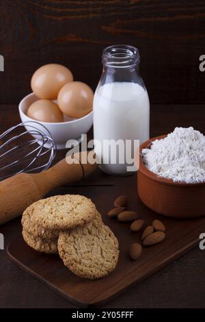 Les cookies d'avoine fait maison et les ingrédients pour la cuisson sur planche de bois rustique Banque D'Images