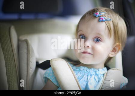 Portrait of a happy little baby girl dans le siège de voiture Banque D'Images