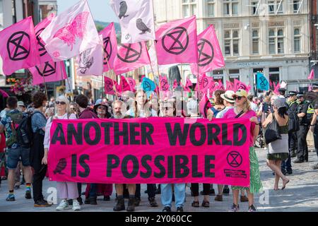 Windsor, Royaume-Uni. 1er septembre 2024. Des centaines de manifestants contre le changement climatique extinction Rebellion étaient à Windsor, Berkshire, ce matin, dans le cadre de leur week-end de protestation de trois jours pour améliorer la démocratie à Windsor. Ils ont marché de leur camp à Home Park à travers les rues jusqu'au château de Windsor où ils ont organisé un rassemblement et des activités de sensibilisation aux visiteurs. Les forces policières et la police à cheval de Thames Valley étaient en attente à l'extérieur du château de Windsor. Crédit : Maureen McLean/Alamy Live News Banque D'Images