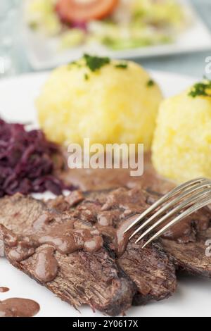 Sauerbraten avec du chou rouge sur une plaque Banque D'Images