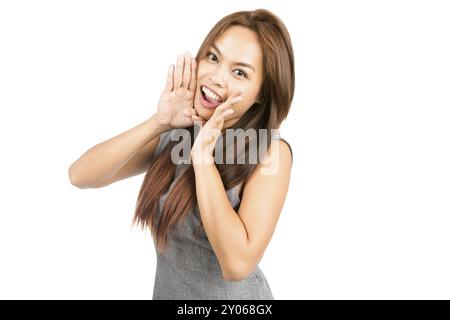 Portrait de belle fille asiatique, robe grise sans manches, cheveux brun clair regardant la caméra, annonçant des mains ventouses autour de la bouche amplifiant le son. Thaï Banque D'Images