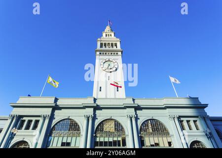 Vue de la façade avant de jour du Ferry Building centré et de la tour de l'horloge en regardant d'un angle bas lors d'une journée ensoleillée et bleu ciel à San Francisco, Californie Banque D'Images