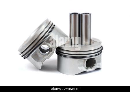 Gros plan des pièces de rechange deux nouveaux pistons avec bielles pour un moteur à essence avec jeux de segments de piston installés sur un fond blanc isolé Banque D'Images