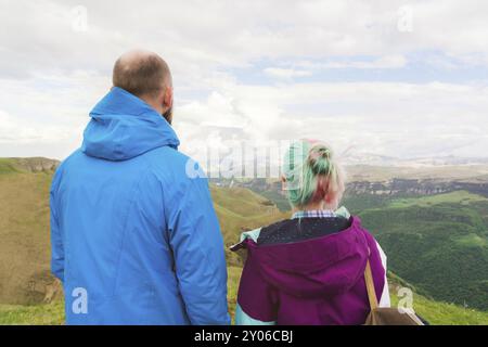 Une paire de touristes hipster se tient à côté de l'autre dans les montagnes sur fond du plateau des vallées et du ciel. Reposez-vous dans le mountai Banque D'Images