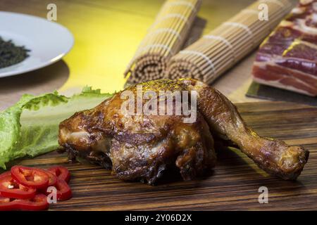 Nature morte avec cuisse de poulet rôtie sur un comptoir de cuisine et d'autres ingrédients Banque D'Images