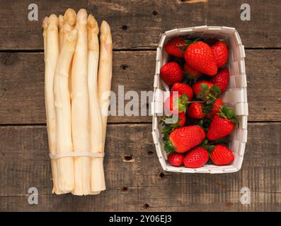 Produits frais bio fraises et asperges blanches sur une table en bois rustique Banque D'Images