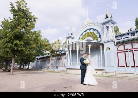 Un beau couple de jeunes mariés s'étreignent sur le fond du bâtiment vintage de la galerie d'exposition. Le concept d'une promenade de mariage an Banque D'Images