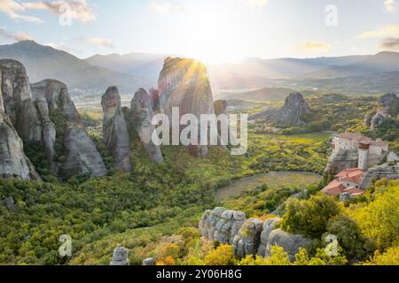 Grèce septentrionale. Le petit monastère rocheux des Météores dans les montagnes de Thessalie. Rayons de coucher de soleil d'été sur la vallée verdoyante au large de Kalambaka Banque D'Images