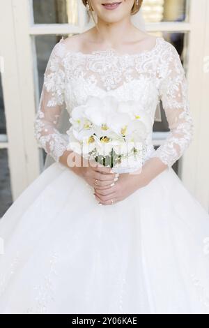 Gros plan d'une mariée tenant un bouquet de mariage. Le concept d'un festival de mariage et d'une vie heureuse Banque D'Images