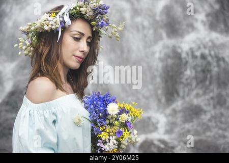 Gros plan portrait d'une fille avec une couronne sur la tête contre une cascade dans la nature Banque D'Images