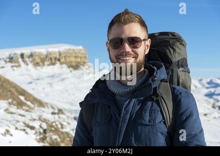 Portrait d'un heureux riant voyageur Hipster avec une barbe dans des lunettes de soleil dans la nature. Un homme randonnant dans les montagnes avec un sac à dos et scandinave Banque D'Images