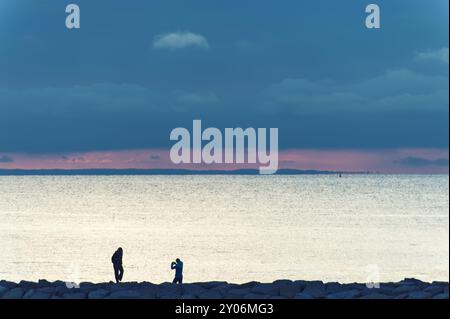 2 personnes le soir sur le quai du port de Timmendorf Banque D'Images