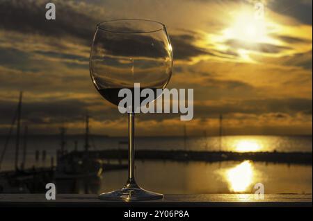 Un verre de vin rouge se tient sur la balustrade d'un balcon Banque D'Images