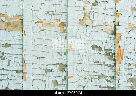 Un grand fond texturé. Peinture bleue exfoliante en gros morceaux manquants sur le revêtement en bois. Le concept de ruine et d'antiquité vintage Banque D'Images