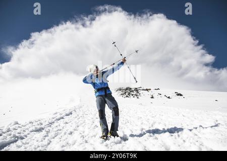 Backpacker dans les montagnes prétend qu'il tire un arc en utilisant l'exemple des bâtons pour la marche scandinave dans le contexte d'un St imminent Banque D'Images