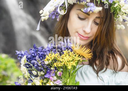 Gros plan portrait d'une fille avec une couronne sur la tête contre une cascade dans la nature Banque D'Images