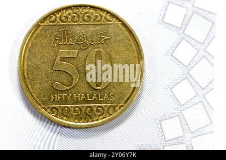 Pièce d'or demi riyal 50 cinquante Halalas, présente une ornementation florale en trèfle sur le haut et le bas et les bras de l'Arabie saoudite au centre avec t Banque D'Images