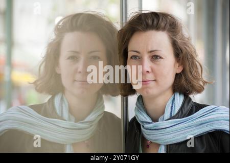Jeune femme reflète dans une vitrine Banque D'Images