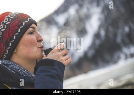 Belle fille caucasienne tient une tasse de thé à l'extérieur, l'hiver Banque D'Images