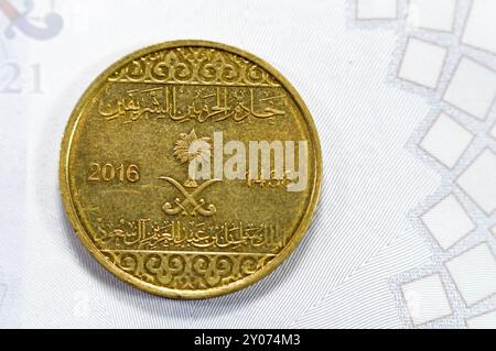 Pièce d'or demi riyal 50 cinquante Halalas, présente une ornementation florale en trèfle sur le haut et le bas et les bras de l'Arabie saoudite au centre avec t Banque D'Images