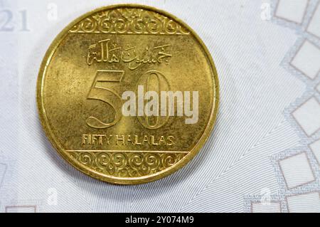 Pièce d'or demi riyal 50 cinquante Halalas, présente une ornementation florale en trèfle sur le haut et le bas et les bras de l'Arabie saoudite au centre avec t Banque D'Images