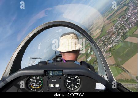 Pilote de planeur dans un planeur au-dessus d'une petite ville Banque D'Images