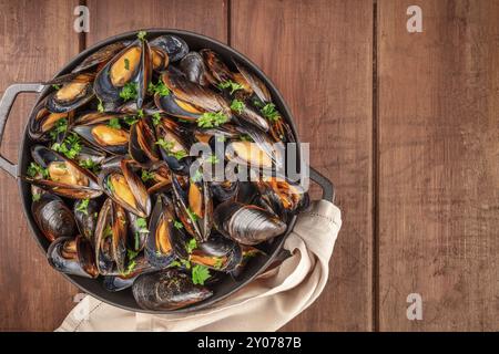 Moules marinière moules marinière,, dans une marmite, overhead view, tourné par le haut sur un fond de bois rustique foncé avec une place pour le texte Banque D'Images