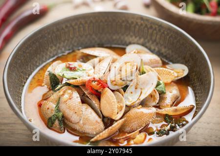 Une délicieuse cuisine thaïlandaise palourdes sautées avec pâte de piment rôti sur sol en bois Banque D'Images