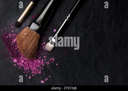 Make-up pinceau de cosmétiques, tourné à partir de ci-dessus, sur un fond noir avec copyspace, un modèle de conception de beauté pour une bannière de maquillage Banque D'Images