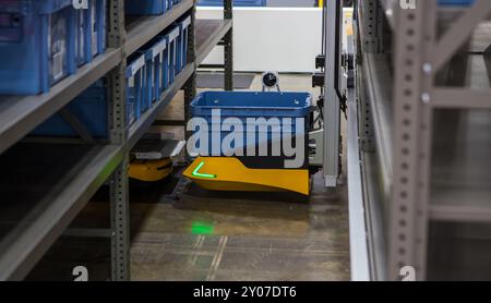 Robot autonome ramassant des matériaux à partir d'un rack multicouche dans un entrepôt industriel moderne. Banque D'Images