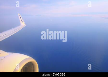 Athènes, Grèce, 22 avril 2019 : logo Ryanair de la compagnie aérienne low-cost sur l'aile et la turbine de l'avion, mer bleue et côte d'Athènes, Europe Banque D'Images