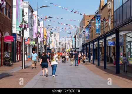 Quartier commerçant Southend on Sea High Street, Essex, Royaume-Uni. Occupé par la chaude journée d'été. Shoppers, excursions à la journée et magasins. Banderoles et présentoirs floraux Banque D'Images