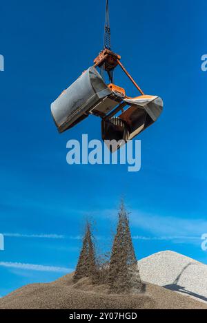 La grue à grue remplit le sable sur une colline Banque D'Images