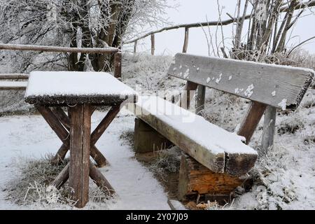 Banc enneigé sur un sentier de randonnée en hiver Banque D'Images