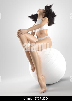 Jeune femme avec un corps mince et des cheveux bruns volants assis sur une boule d'exercice blanche isolée sur fond blanc. Fitness et concept de santé. Photorea Banque D'Images