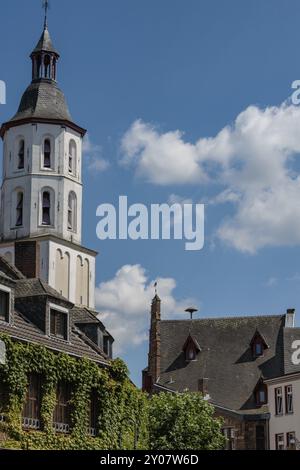 Tour de l'église blanche s'élève au-dessus des bâtiments historiques, entouré par le ciel bleu et les nuages, les plantes vertes grimpent les bâtiments, Xanten, Bas Rhin, Nord Banque D'Images