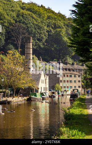 Les bateaux étroits de canal amarrés par l'ancien moulin Crossleys sur le canal de Rochdale dans la ville de marché de Calderdale Valley de Hebden Bridge West Yorkshire Angleterre Banque D'Images